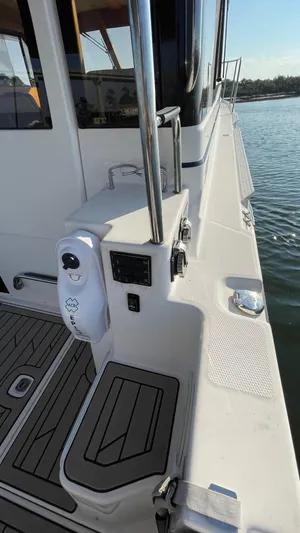  Yacht Photos Pics 2022 Cutwater C-32 Sedan boat deck with railing, docked on calm water.