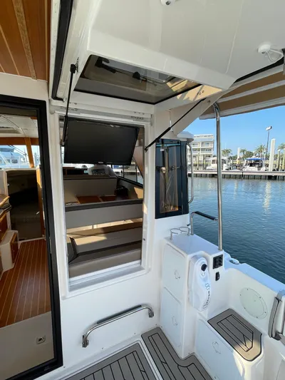  Yacht Photos Pics 2022 Cutwater C-32 Sedan boat interior with open hatch, dockside view, and modern amenities.