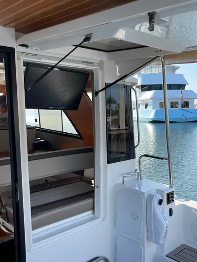  Yacht Photos Pics 2022 Cutwater C-32 Sedan interior with TV, docked near a blue yacht.