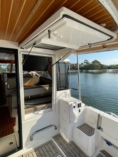  Yacht Photos Pics 2022 Cutwater C-32 Sedan boat interior with open hatch, docked by a serene lake.