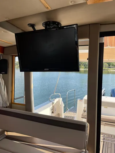  Yacht Photos Pics Interior view of 2022 Cutwater C-32 Sedan with mounted TV and water backdrop.