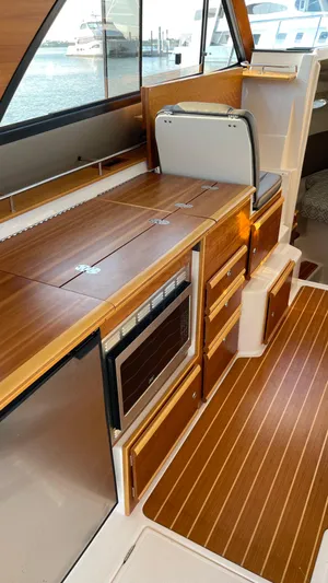  Yacht Photos Pics 2022 Cutwater C-32 Sedan interior with wood finish and modern kitchen amenities.