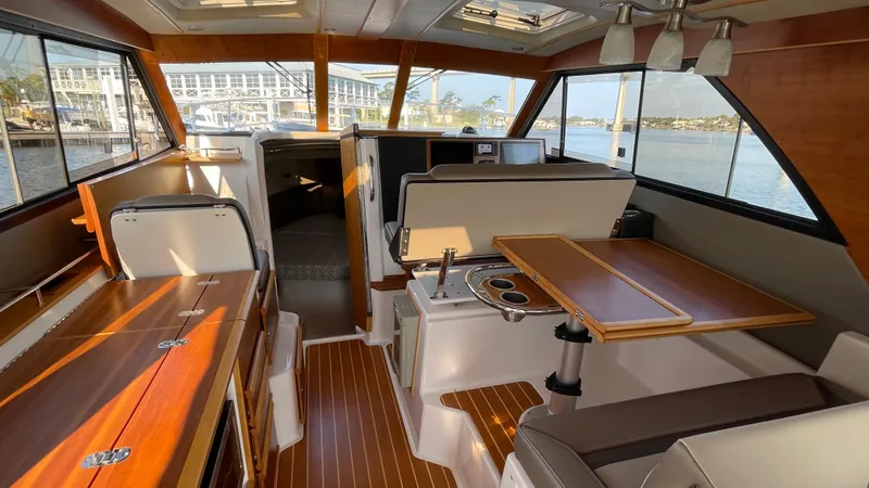  Yacht Photos Pics 2022 Cutwater C-32 Sedan interior with wood accents and panoramic windows.