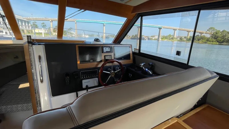  Yacht Photos Pics 2022 Cutwater C-32 Sedan interior with steering wheel, dashboard, and water view.