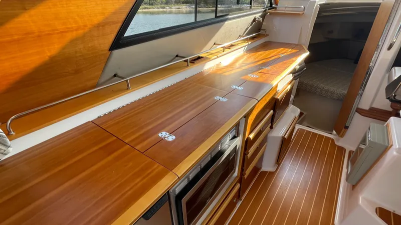  Yacht Photos Pics 2022 Cutwater C-32 Sedan interior with wooden countertops and flooring, showcasing modern design.