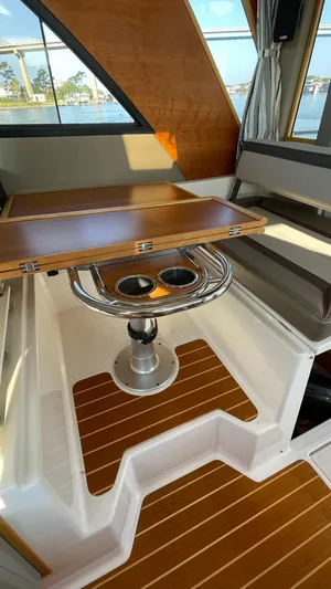  Yacht Photos Pics 2022 Cutwater C-32 Sedan interior with wooden table and seating area.
