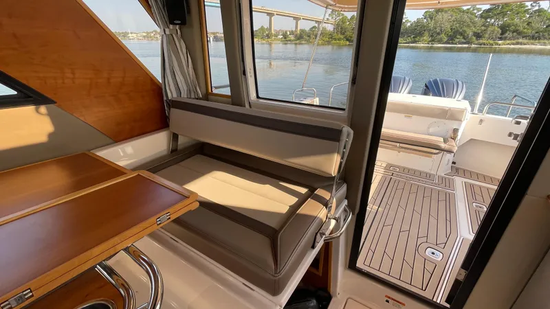  Yacht Photos Pics 2022 Cutwater C-32 Sedan interior with seating, table, and view of water through windows.