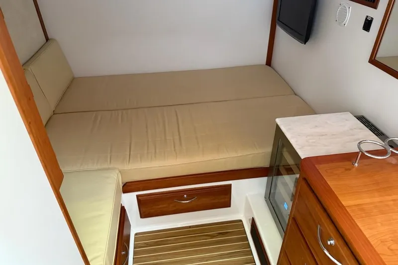Brio Yacht Photos Pics 2012 Sabre 48 Salon Express interior with beige bedding, wooden cabinetry, and a small TV.