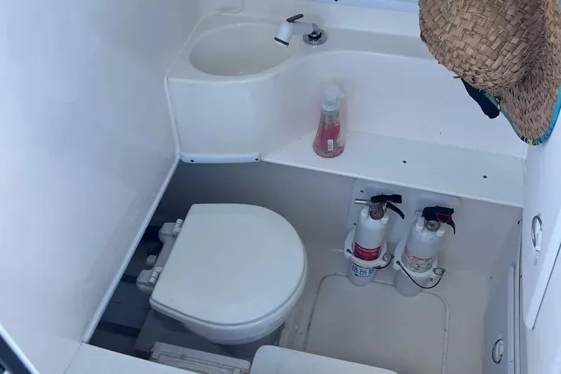  Yacht Photos Pics 2024 Contender 30 Tournament boat bathroom with toilet, sink, and fire extinguishers.