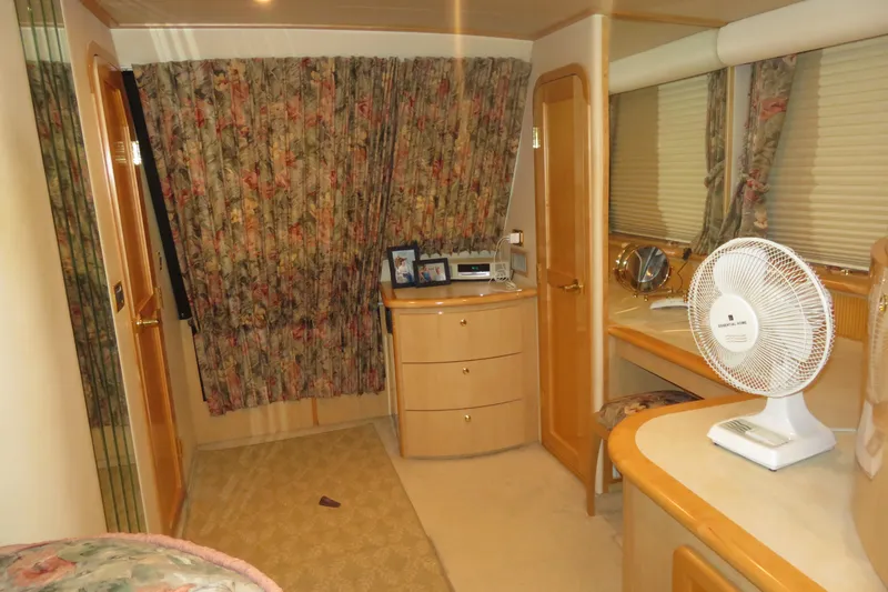 Just Us Yacht Photos Pics Interior of 2000 Bluewater Yachts 5800 with floral curtains and wooden cabinetry.
