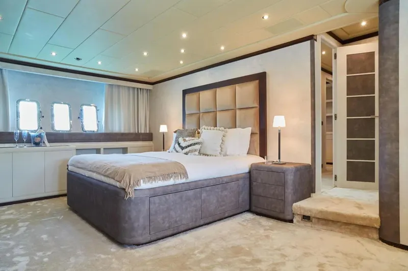  Yacht Photos Pics Luxurious bedroom interior on 2003 Mangusta 108 yacht, featuring elegant decor and ambient lighting.