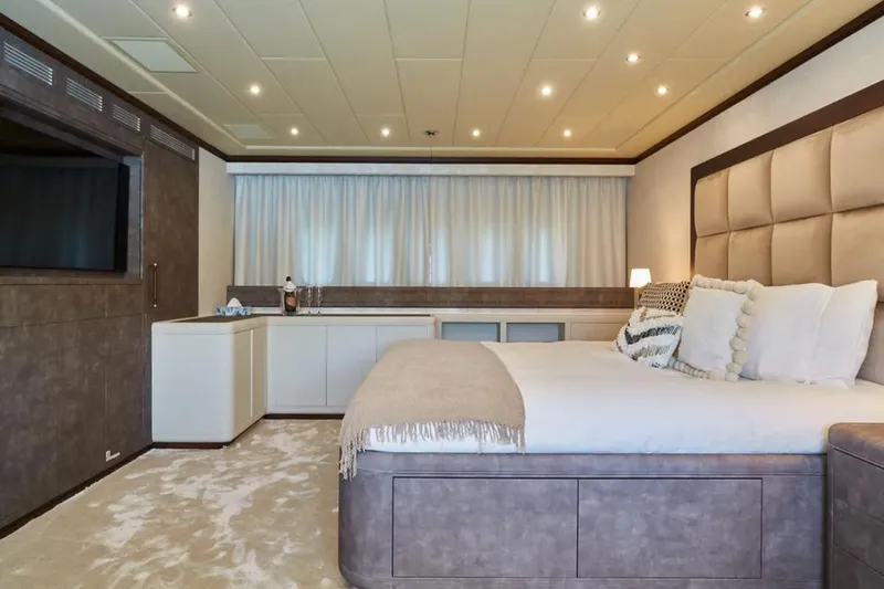  Yacht Photos Pics Luxurious bedroom interior on 2003 Mangusta 108 yacht, featuring elegant decor and ambient lighting.