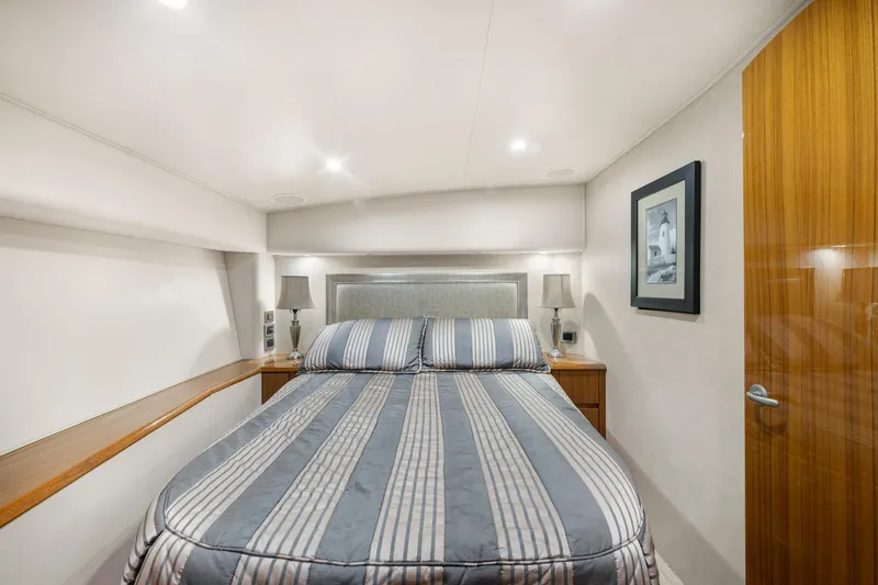  Yacht Photos Pics Luxurious bedroom interior of 2009 Viking 50 Convertible yacht with striped bedding and elegant decor.