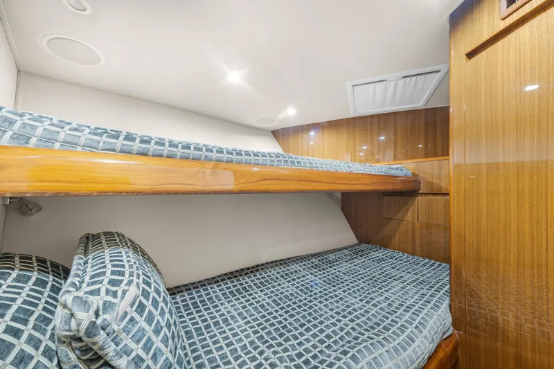  Yacht Photos Pics Interior of 2009 Viking 50 Convertible yacht with wooden bunk beds and patterned bedding.