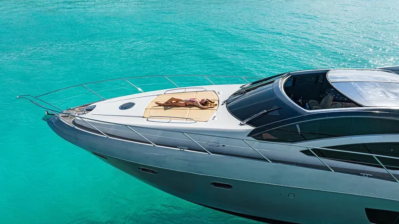  Yacht Photos Pics 2011 Sunseeker 64 Predator yacht on turquoise water, person sunbathing on deck.