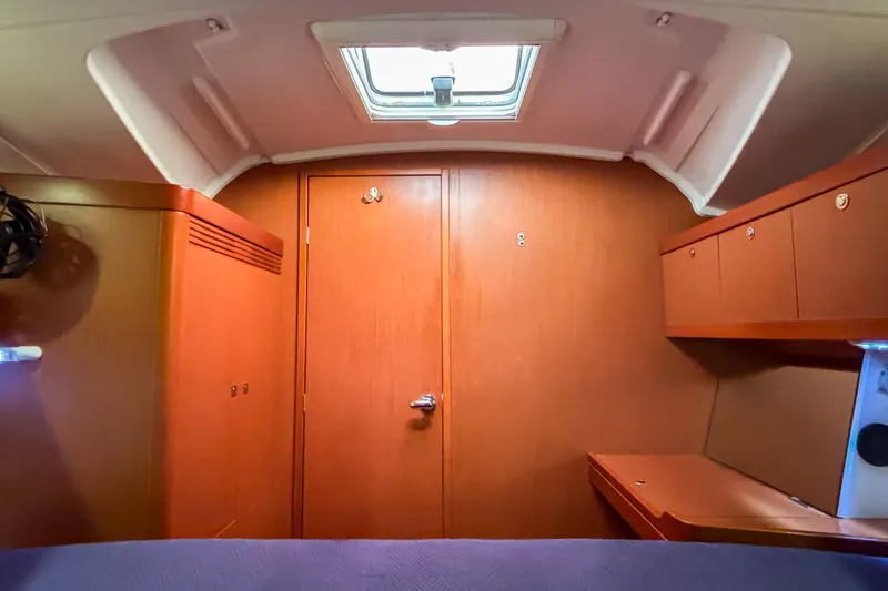 Marley Yacht Photos Pics Interior cabin of 2015 Beneteau Oceanis 37 sailboat, featuring wood paneling and storage.