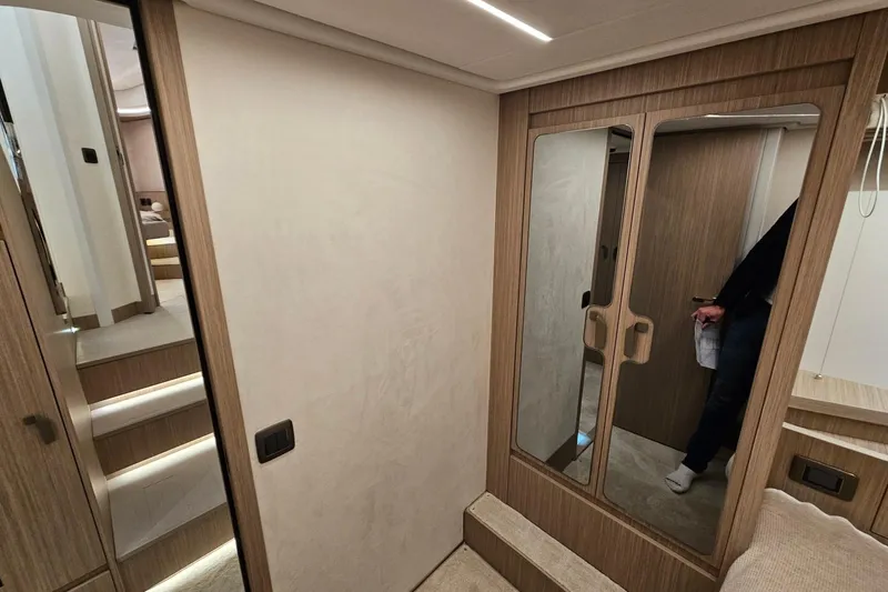  Yacht Photos Pics Modern interior of 2026 Prestige F4.9 yacht with wooden finishes and mirrored doors.