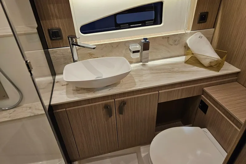  Yacht Photos Pics Modern bathroom in 2026 Prestige F4.9 yacht with sleek sink and wooden cabinetry.