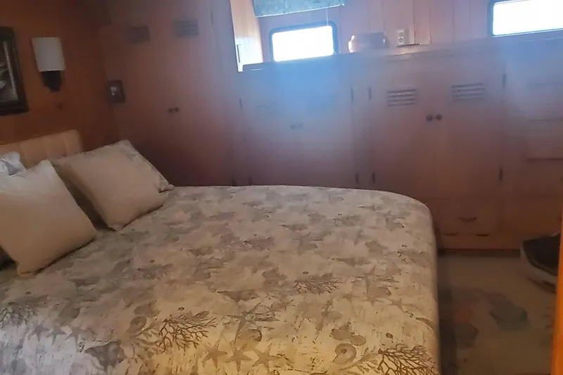 Regal Countess Yacht Photos Pics Cozy bedroom in 1965 Tacoma Boat Works Bill Garden Motor Yacht, featuring wooden cabinetry and nautical bedding.