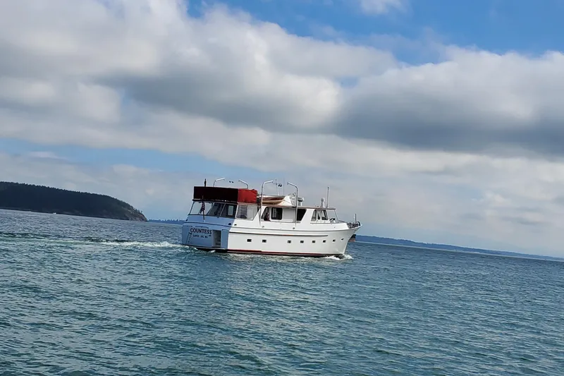 Regal Countess Yacht Photos Pics 1965 Tacoma Boat Works Bill Garden Motor Yacht cruising on open water under cloudy sky.