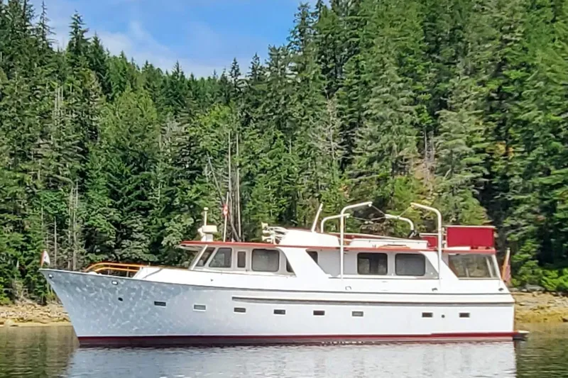 Regal Countess Yacht Photos Pics 1965 Tacoma Boat Works Bill Garden Motor Yacht on tranquil water, surrounded by lush forest.
