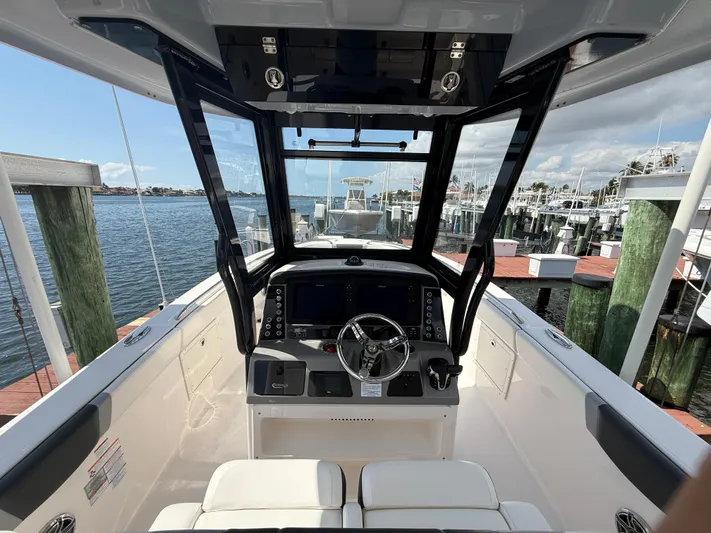 272-203 Brokerage Sebastian Yacht Photos Pics 2023 Robalo R272 Center Console boat interior at a marina dock.