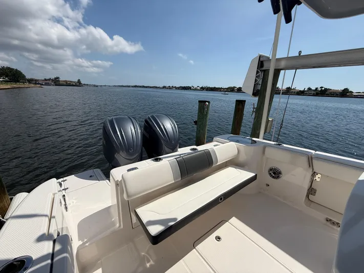 272-203 Brokerage Sebastian Yacht Photos Pics 2023 Robalo R272 Center Console boat with dual engines, docked by a scenic waterfront.