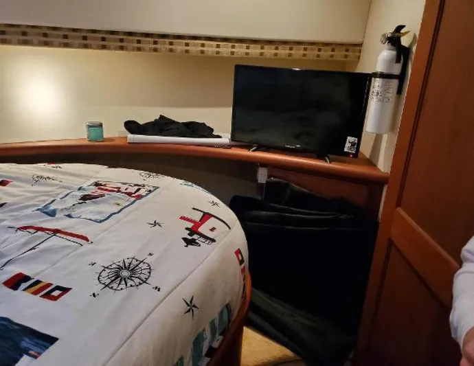  Yacht Photos Pics 2005 Silverton 34 Convertible cabin interior with nautical-themed bedding and a small TV.