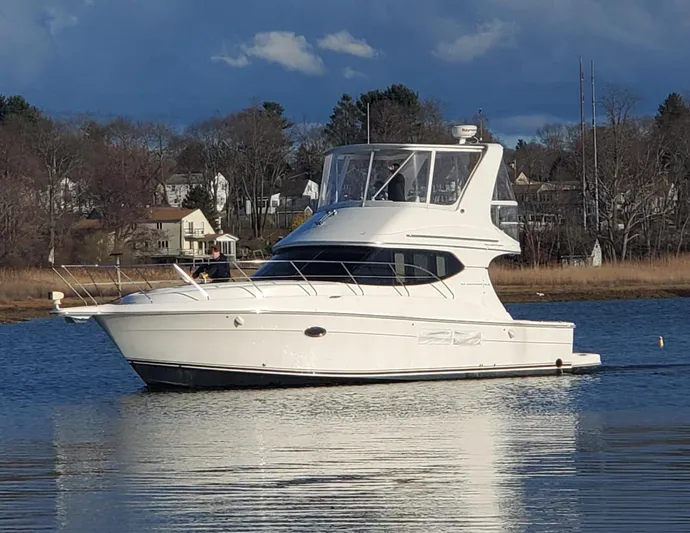 Yacht Photos Pics 2005 Silverton 34 Convertible yacht on calm water, with scenic background.