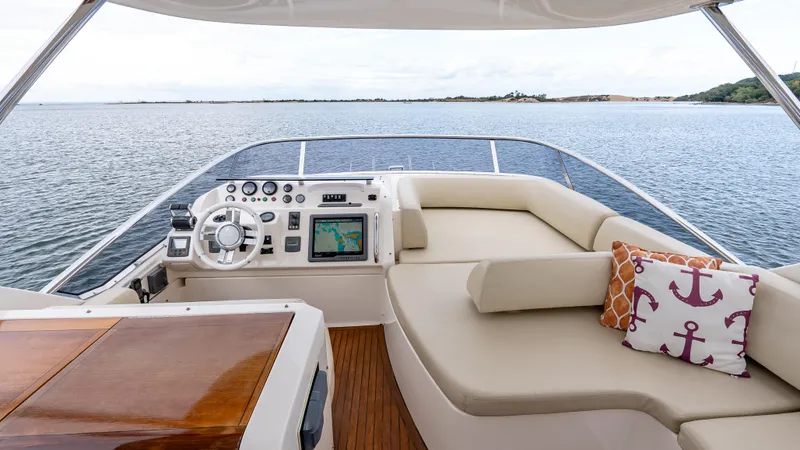 Christine Yacht Photos Pics Flybridge of 2011 Azimut 58 yacht with steering wheel, navigation system, and cushioned seating.