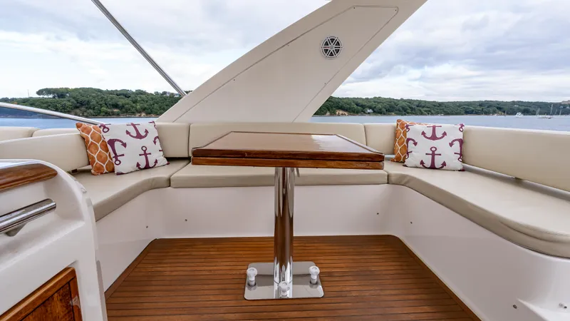 Christine Yacht Photos Pics Azimut 58 Flybridge 2011 yacht interior with cushioned seating and wooden table.