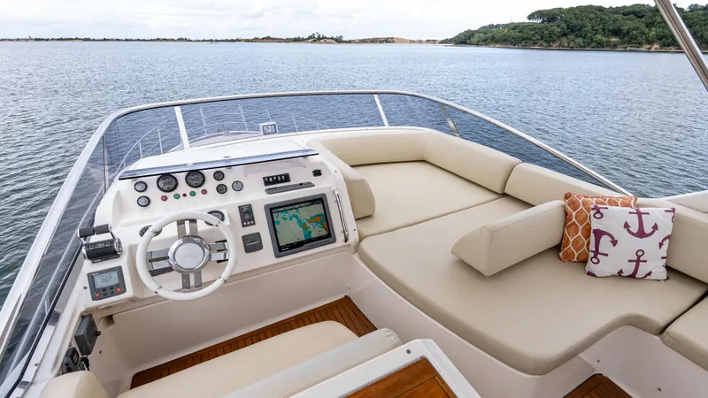Christine Yacht Photos Pics Flybridge of 2011 Azimut 58 yacht with navigation controls and seating, overlooking calm waters.
