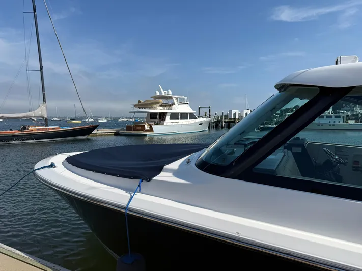 Adios Yacht Photos Pics 2018 Pursuit DC 325 Dual Console boat docked in a marina with other vessels.