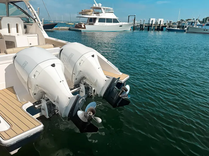 Adios Yacht Photos Pics 2018 Pursuit DC 325 Dual Console with twin outboard engines docked in a marina.