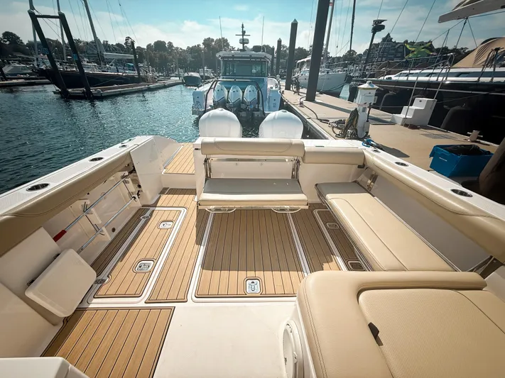 Adios Yacht Photos Pics 2018 Pursuit DC 325 Dual Console boat interior at marina, featuring spacious seating and teak flooring.