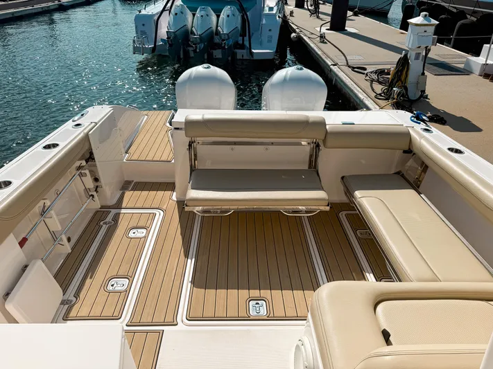 Adios Yacht Photos Pics 2018 Pursuit DC 325 Dual Console boat interior with teak flooring and seating at marina.