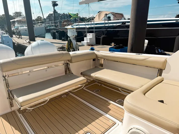 Adios Yacht Photos Pics 2018 Pursuit DC 325 Dual Console boat interior with beige seating and wooden deck.