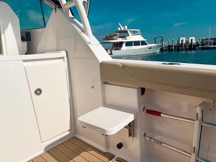 Adios Yacht Photos Pics 2018 Pursuit DC 325 Dual Console boat interior with docked yacht in background.
