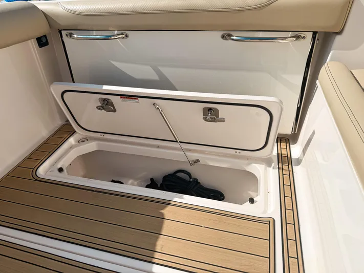 Adios Yacht Photos Pics 2018 Pursuit DC 325 Dual Console storage compartment with open hatch and teak flooring.