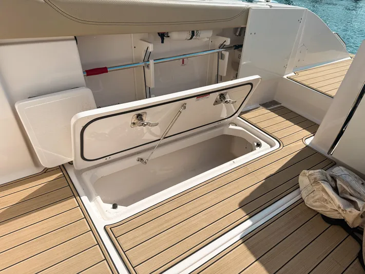 Adios Yacht Photos Pics 2018 Pursuit DC 325 Dual Console boat storage compartment open on teak deck.