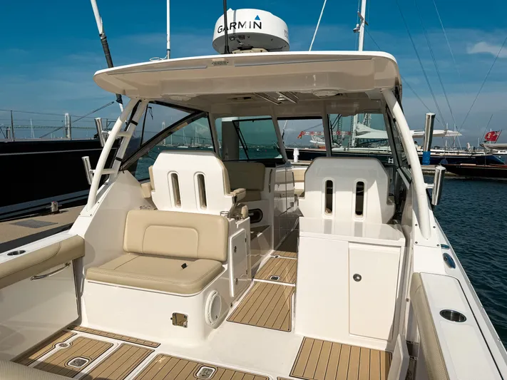 Adios Yacht Photos Pics 2018 Pursuit DC 325 Dual Console boat interior with beige seating and Garmin equipment.