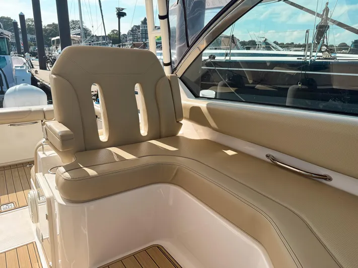 Adios Yacht Photos Pics 2018 Pursuit DC 325 Dual Console boat interior with beige seating and wooden deck.
