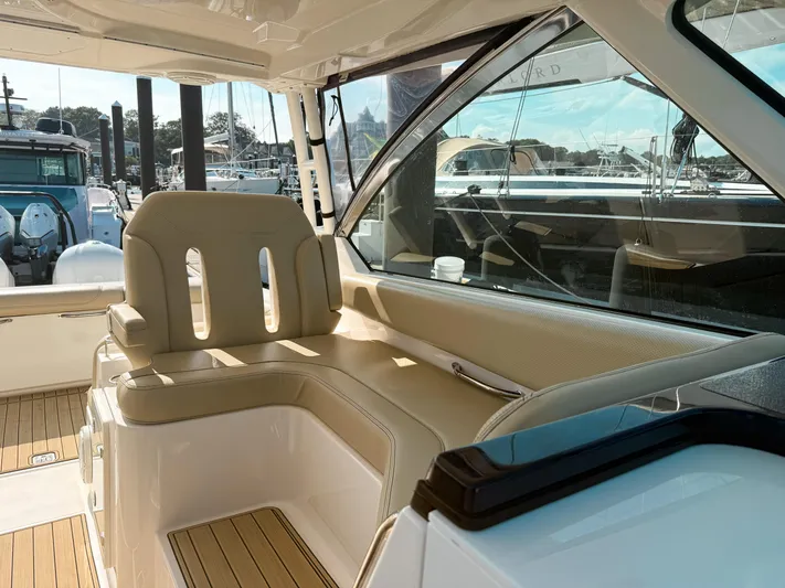 Adios Yacht Photos Pics 2018 Pursuit DC 325 Dual Console interior with beige seating and marina view.