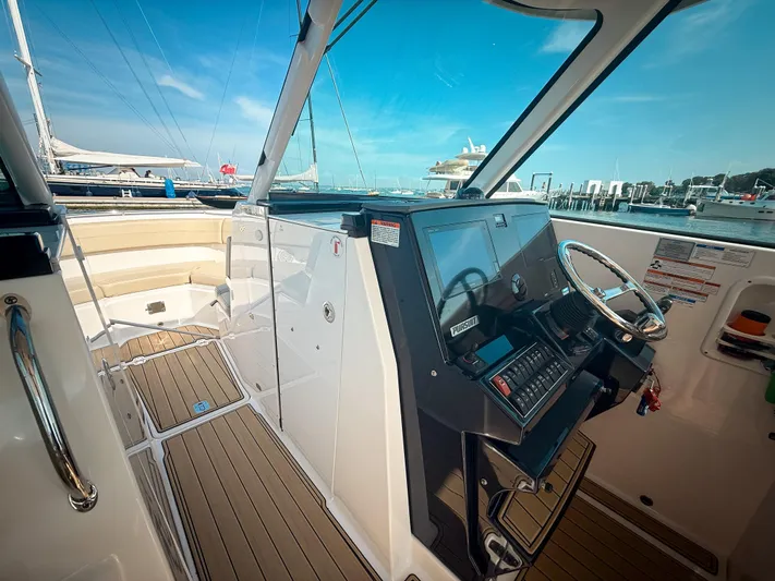 Adios Yacht Photos Pics 2018 Pursuit DC 325 Dual Console boat interior with helm, steering wheel, and docked marina view.