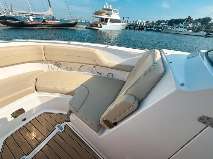 Adios Yacht Photos Pics 2018 Pursuit DC 325 Dual Console boat interior with beige seating, docked in a marina.