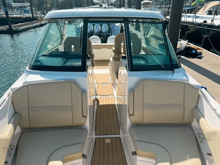 Adios Yacht Photos Pics 2018 Pursuit DC 325 Dual Console boat with spacious seating and sleek design at a marina.