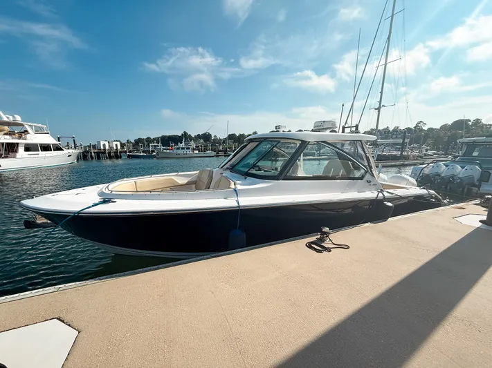 Adios Yacht Photos Pics 2018 Pursuit DC 325 Dual Console boat docked at marina under clear blue sky.