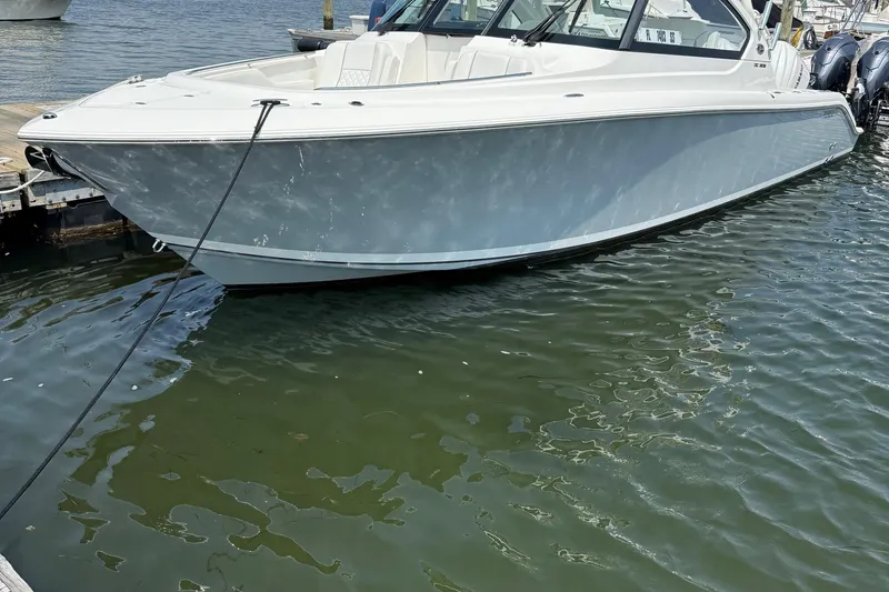  Yacht Photos Pics 2024 Pursuit DC 306 Dual Console boat docked on calm water.