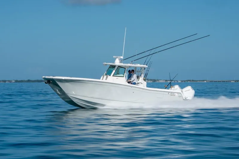  Yacht Photos Pics 2025 Caymas 34 CT boat cruising on open water, clear blue sky background.