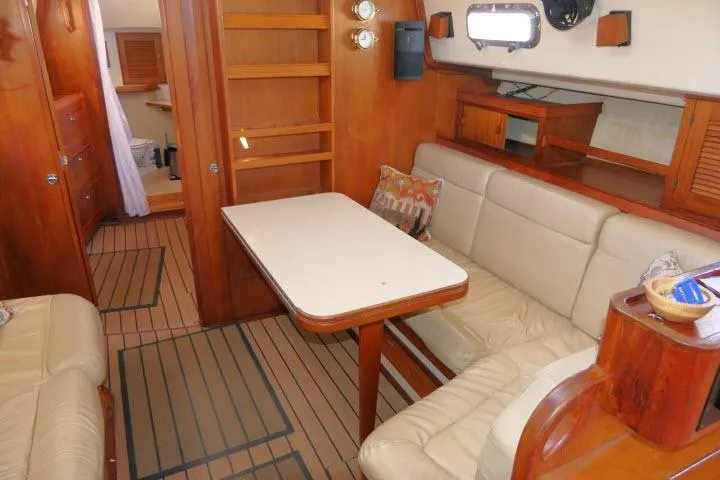 Wild Blue Yacht Photos Pics Interior of 1999 Island Packet 45 sailboat with wooden furnishings and cozy seating area.